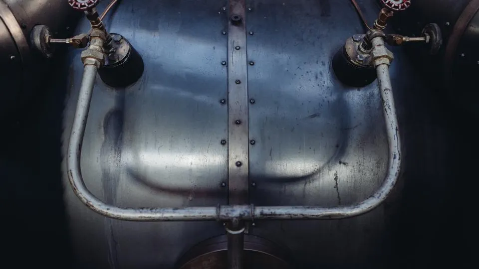 Close-up of valves and piping on a steel tank.